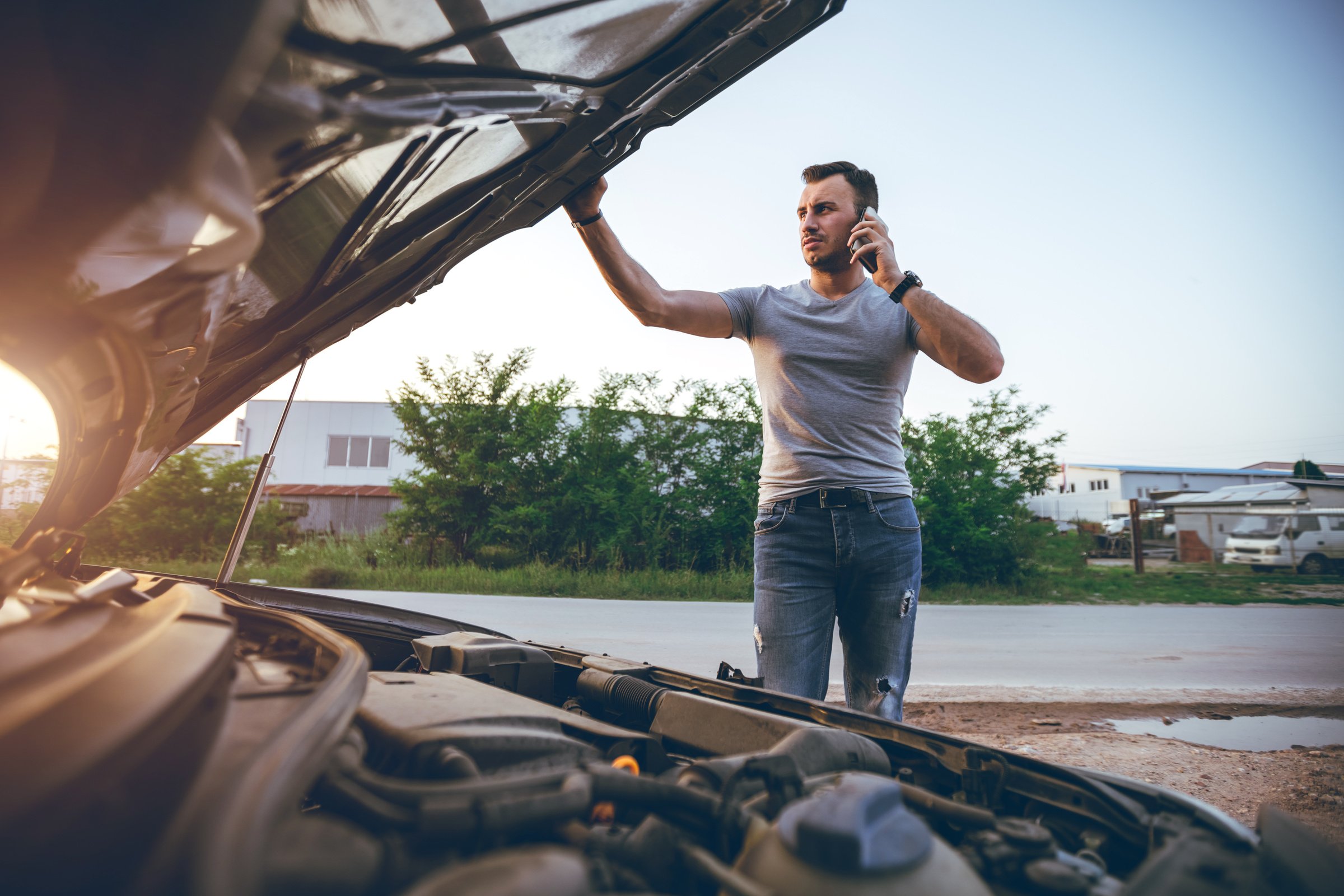 man next to a broken down car